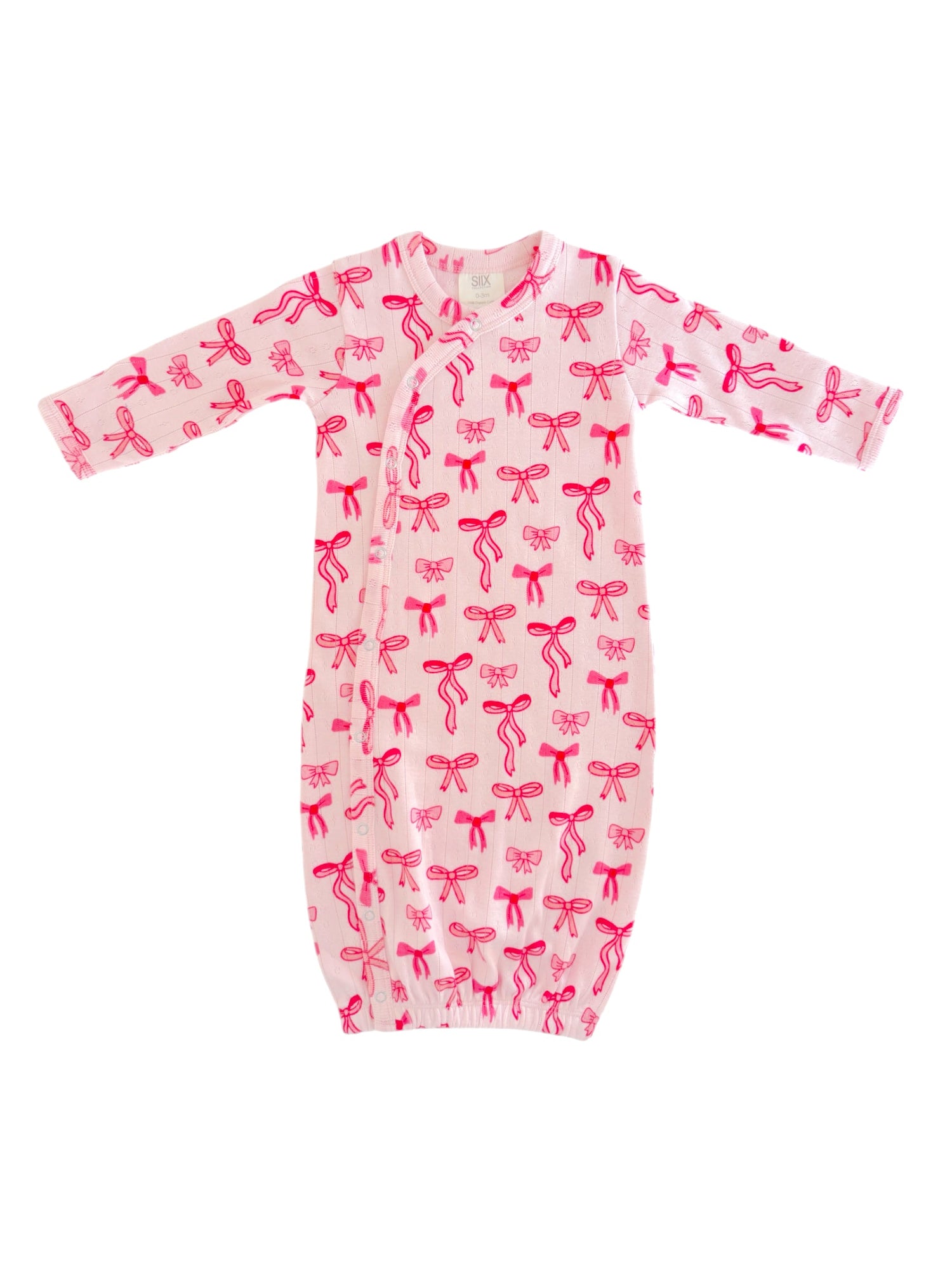 Light pink infant gown with red bow patterns, featuring long sleeves and a gathered bottom for easy dressing.