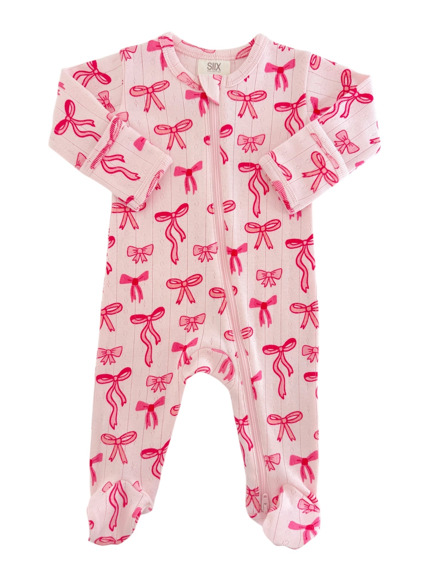 Pink baby onesie with red bow print, featuring long sleeves and a front zipper closure.