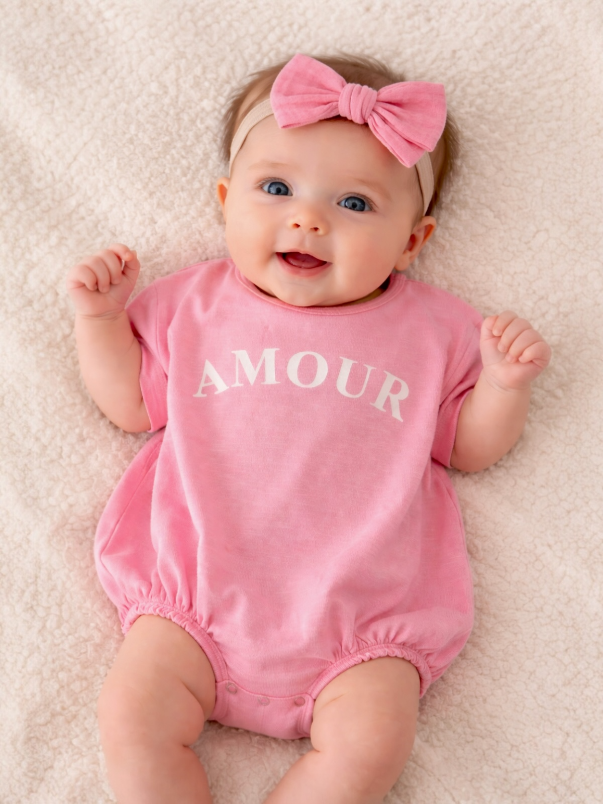 Smiling baby in a pink onesie with 