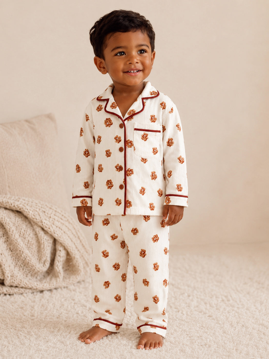 Smiling child in floral pajamas stands on a soft rug, exuding warmth and joy.