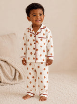 Smiling child in floral pajamas stands on a soft rug, exuding warmth and joy.