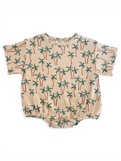 Beige romper with a palm tree print, featuring short sleeves and elasticized bottom. Perfect for warm weather.