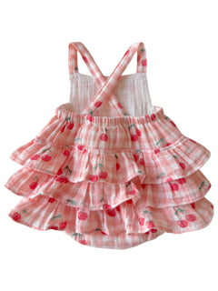 Pink checked dress with cherry patterns and ruffled layers, featuring crisscross straps on the back.
