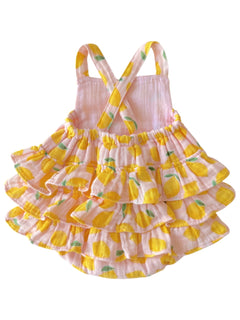 Pink ruffled dress with lemon print and crossed straps, perfect for summer.