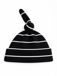 Black ribbed beanie hat with white stripes and a knotted top.