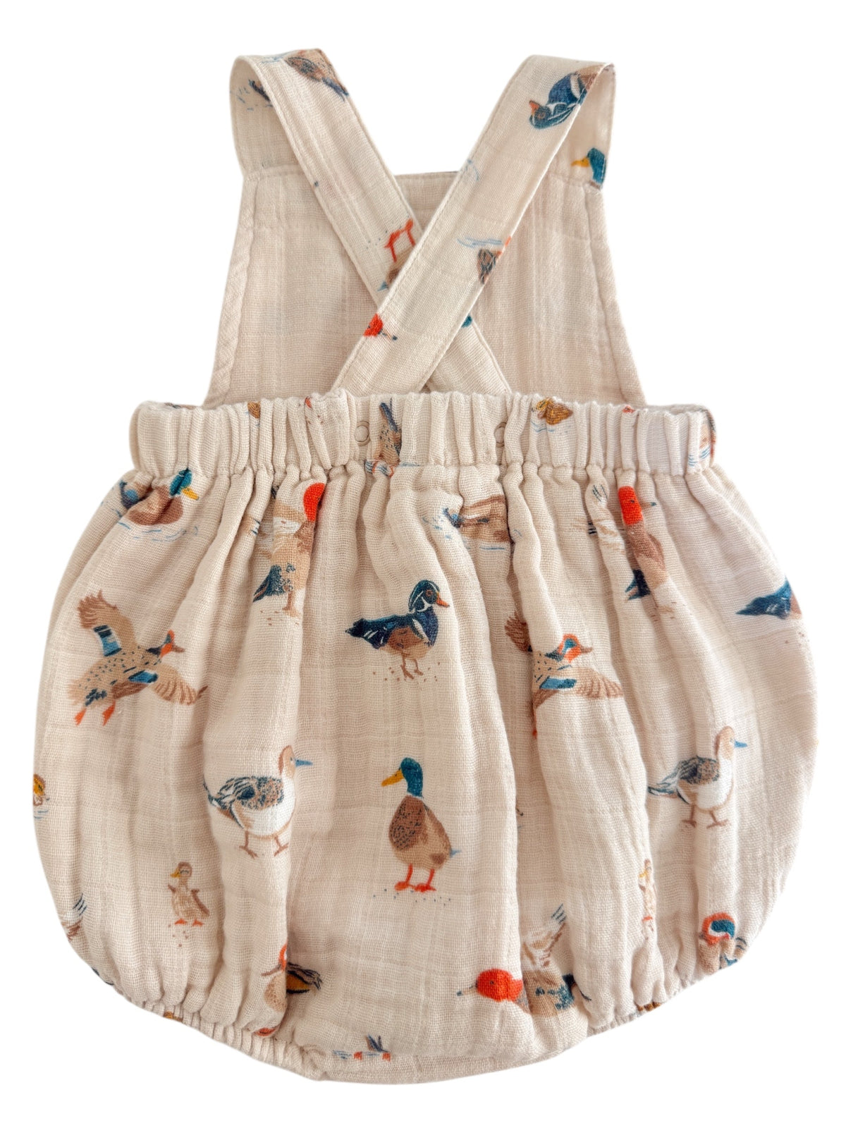 Light beige children's romper with duck illustrations and crossed straps. Ideal for playful outfits.
