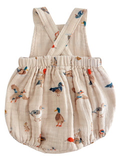 Light beige children's romper with duck illustrations and crossed straps. Ideal for playful outfits.