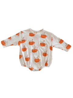 White baby onesie with orange mug patterns, featuring stars and wooden spoons. Ideal for children's apparel.