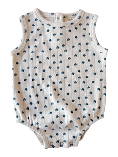 White sleeveless baby romper with blue floral pattern and snap buttons at the bottom.