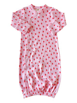 Pink baby gown with red strawberry prints and buttons, featuring long sleeves and gathered bottom.