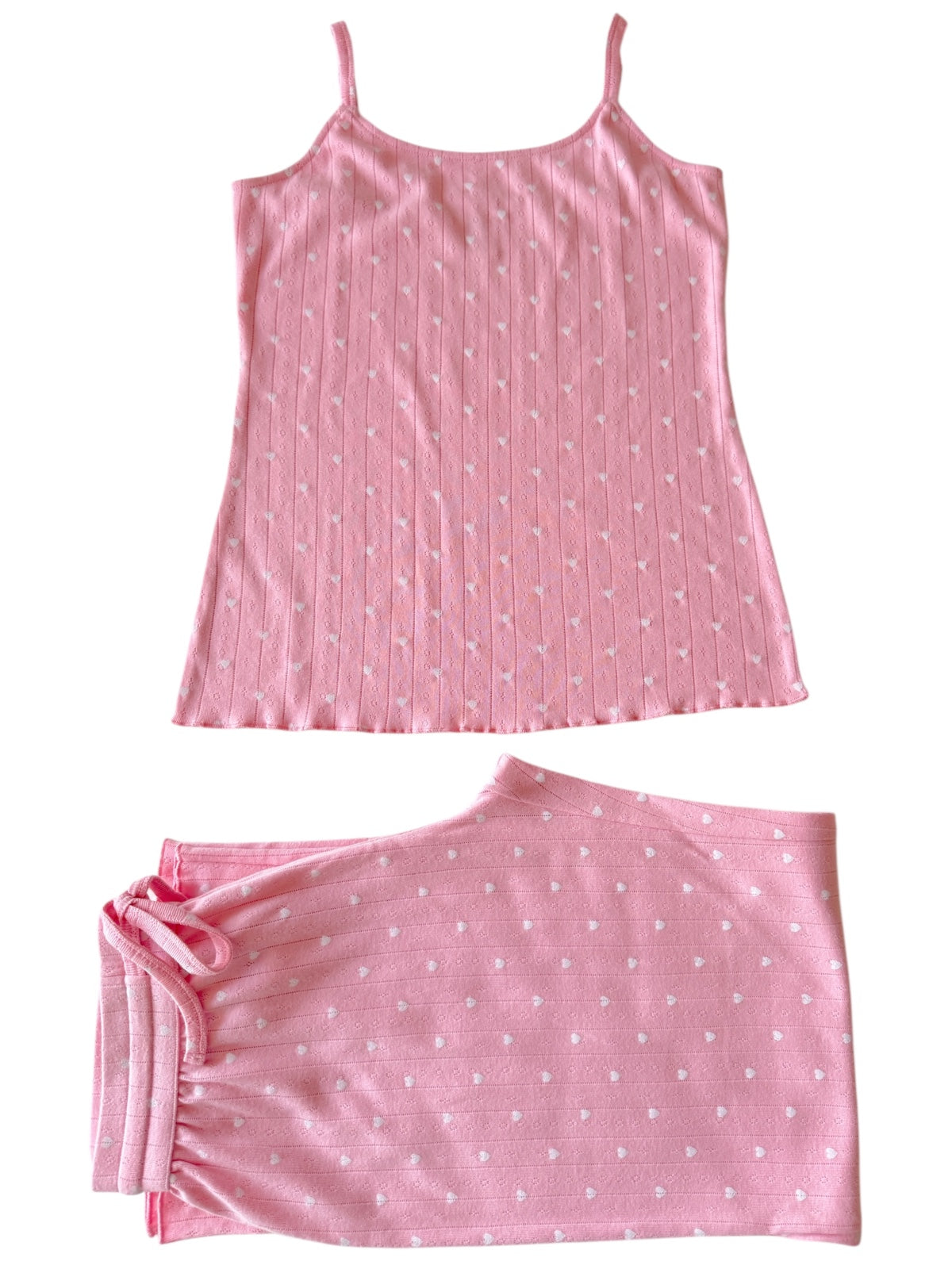 Pink sleep set featuring a sleeveless top and matching shorts with heart patterns. Ideal for comfortable lounging.