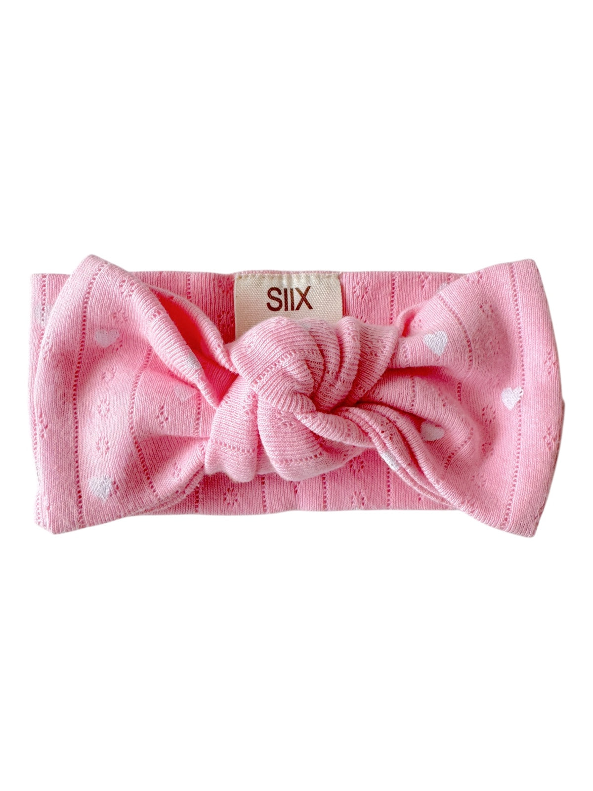 Pink headband with a knot and heart patterns, labeled with 