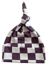 Purple and white checkered knit hat with a tied top.