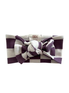 Purple and white striped headband with a bow, featuring a brand tag.