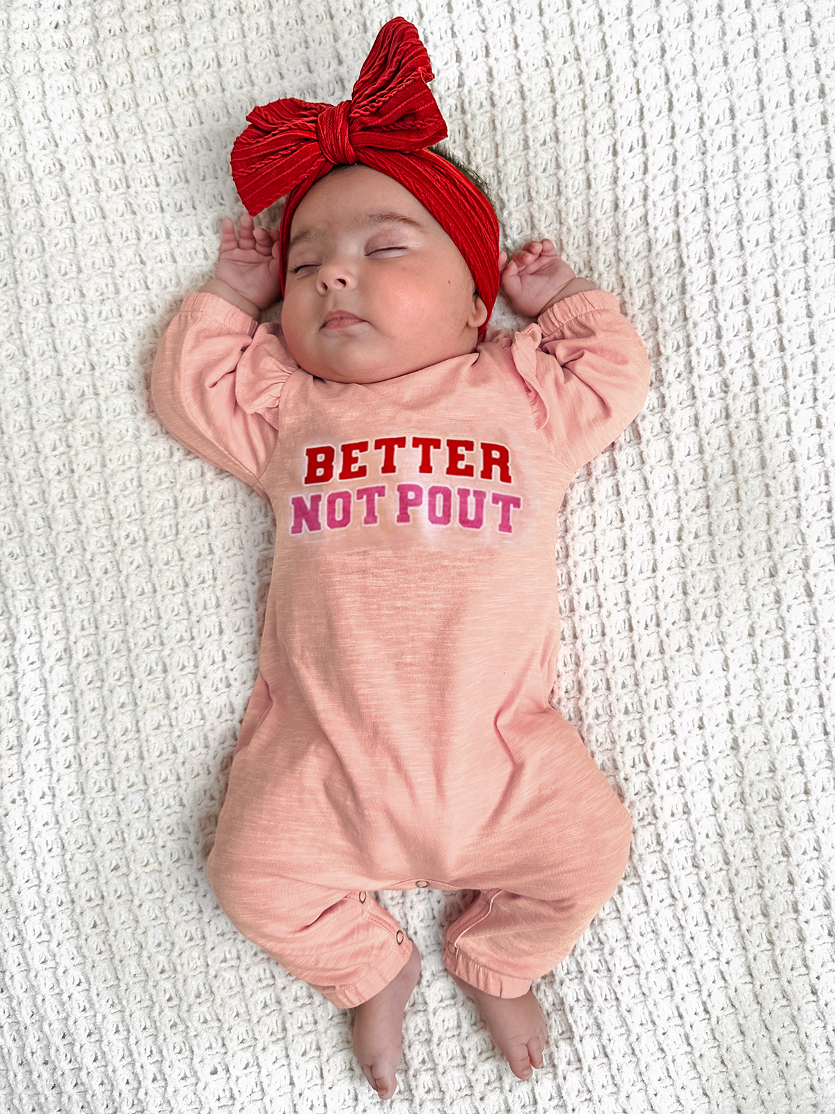 Baby wearing a pink onesie with 