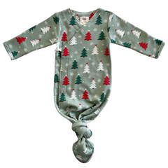 Green baby swaddle with red and white Christmas trees and snowflakes, featuring long sleeves and a knotted bottom.