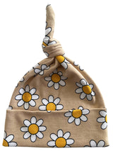 Beige baby hat with a knot, featuring a cheerful daisy print in white and yellow.