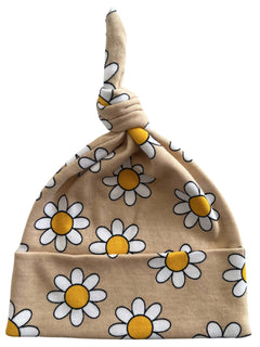 Beige baby hat with a knot, featuring a cheerful daisy print in white and yellow.