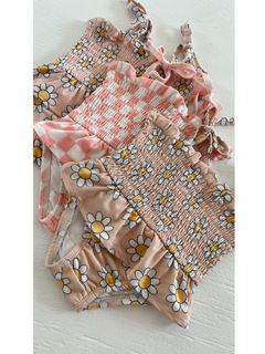 Four colorful swimsuits with floral and checkered patterns arranged neatly on a white surface.