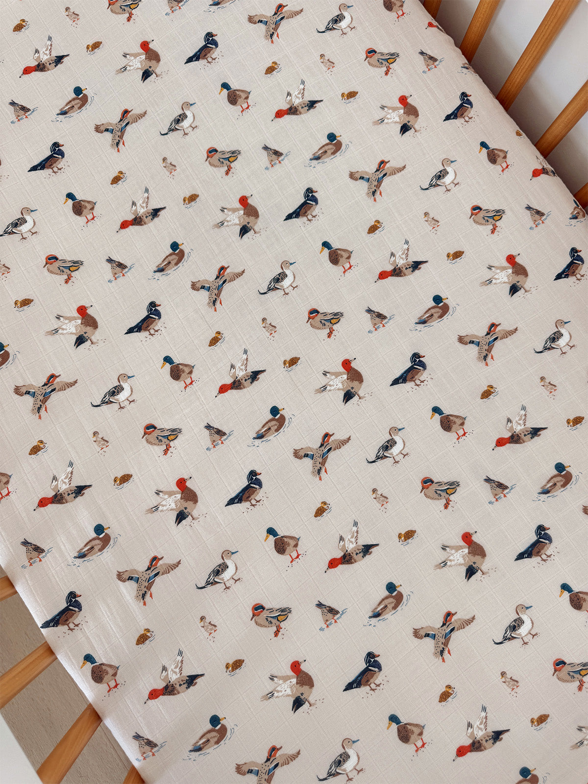 Patterned fabric featuring colorful, whimsical illustrations of various birds on a light background.