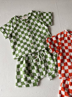 Child's checkered outfit in green and white with matching shorts; includes a red and white checked set.