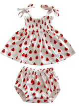 White dress and matching bloomer set with red ladybug prints and tie straps. Perfect for warm-weather outings.