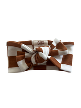 Brown and white checkered headband with a knot detail, displayed on a white background.