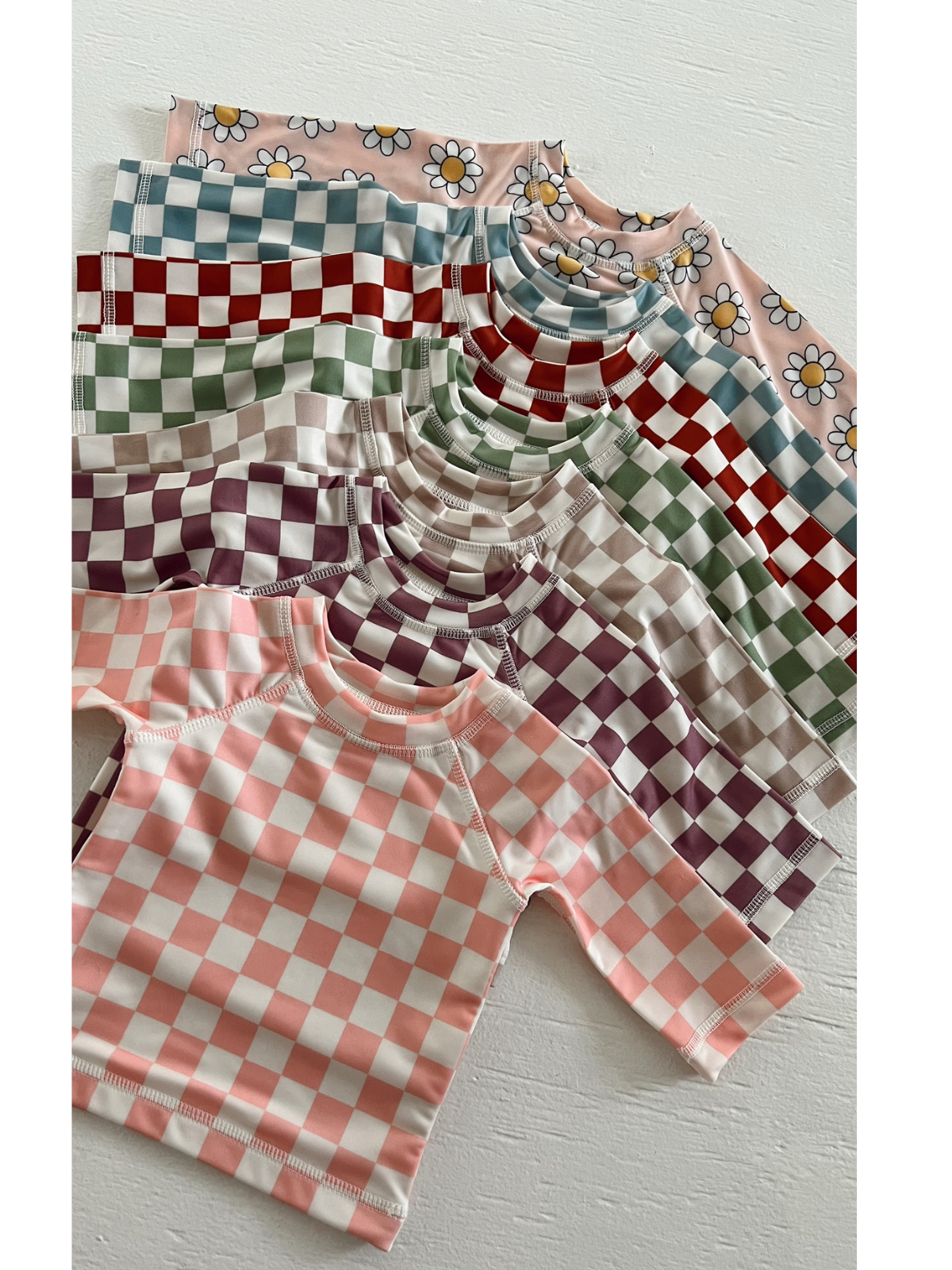 Colorful patterned short-sleeve shirts displayed in a layered arrangement on a white background.