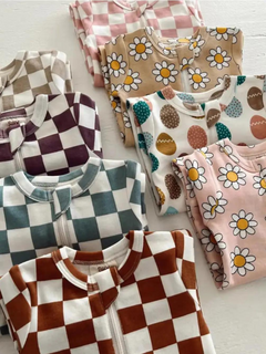 Colorful children's pajamas with various patterns, including checks, daisies, and Easter eggs, neatly folded.
