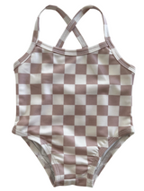 Blush and white checkered pattern one-piece swimsuit with crisscross straps. Perfect for summer fun!